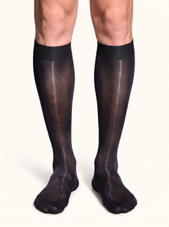 Front view of a man standing in NYLO 10D sheer black dress socks below the knee