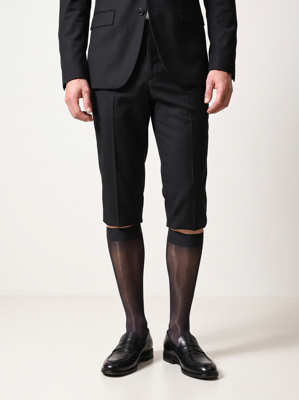 Man in a black blazer and tailored shorts wearing NYLO 10D sheer black dress socks with black loafers