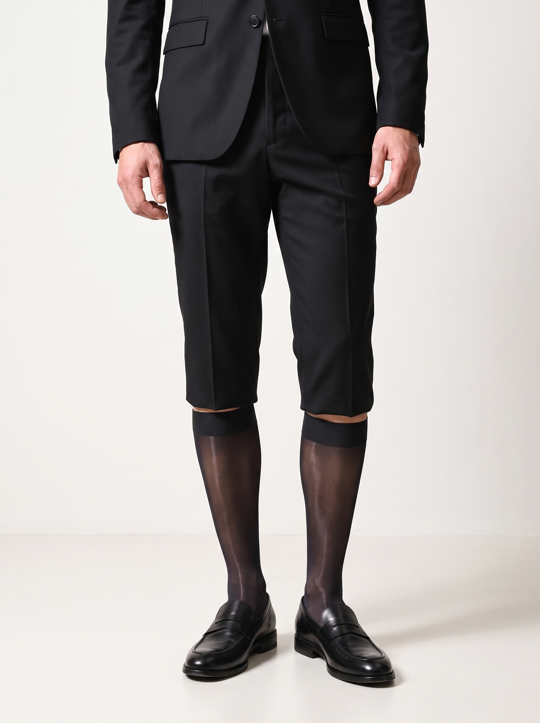 Man in a black blazer and tailored shorts wearing NYLO 10D sheer black dress socks with black loafers