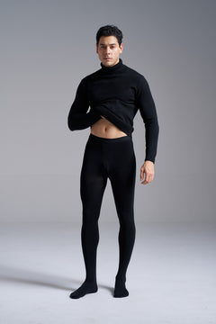 Man in a black turtleneck wearing NYLO 120D Opaque Tights in black, front view from head to toe, lifting the sweater to show the waistband.
