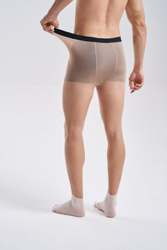 Back view of NYLO 10D Sock Foot Sheer Tights in tan, waist to feet, with the waistband stretched out at one side.